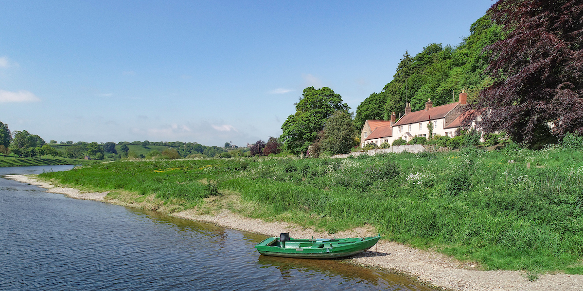 River Tweed with green boat and riverside house