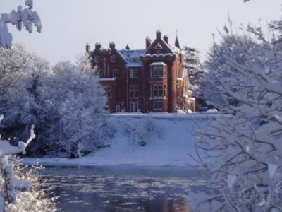 Red sandstone hotel building in snowy riverscape