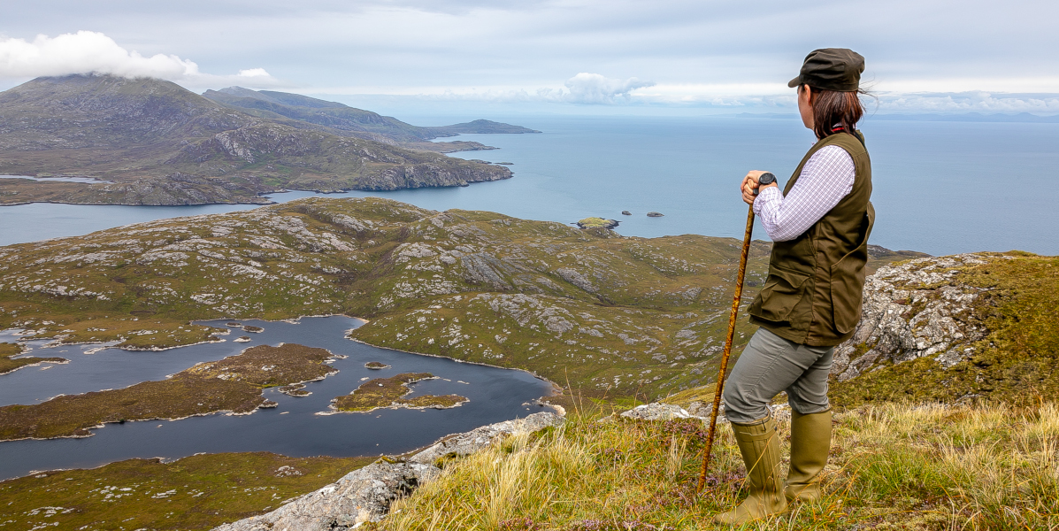 Scottish island woman on hill overlooking sea