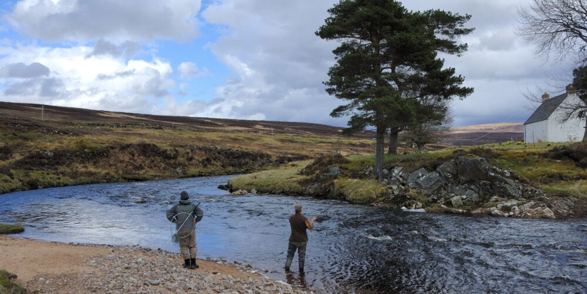 Salmon angler with ghillie fishing