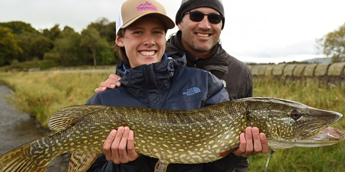 fishing outfitter and client with large pike
