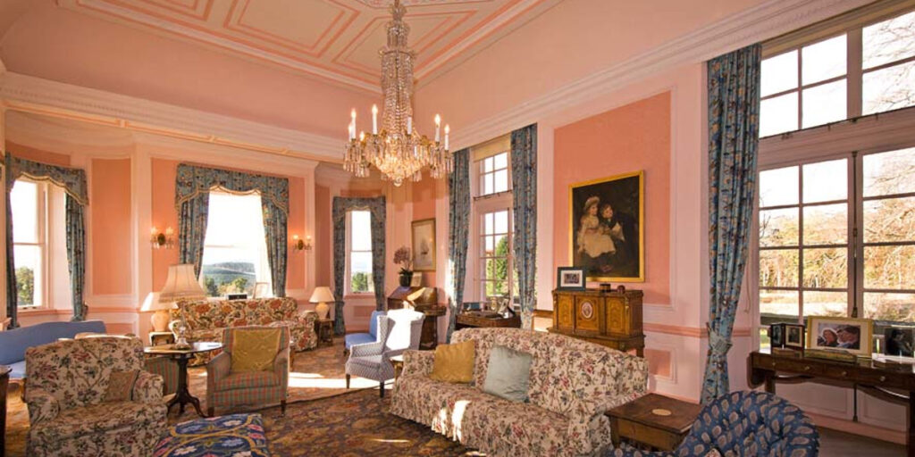 pink coloured Scottish castle drawing room with art and sofas
