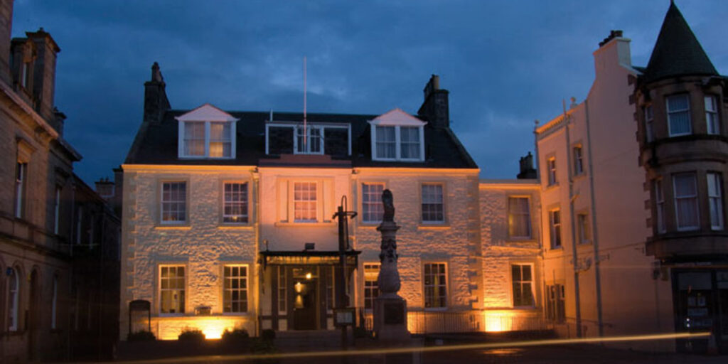 Tontine Hotel Peebles exterior at night white washed with statues