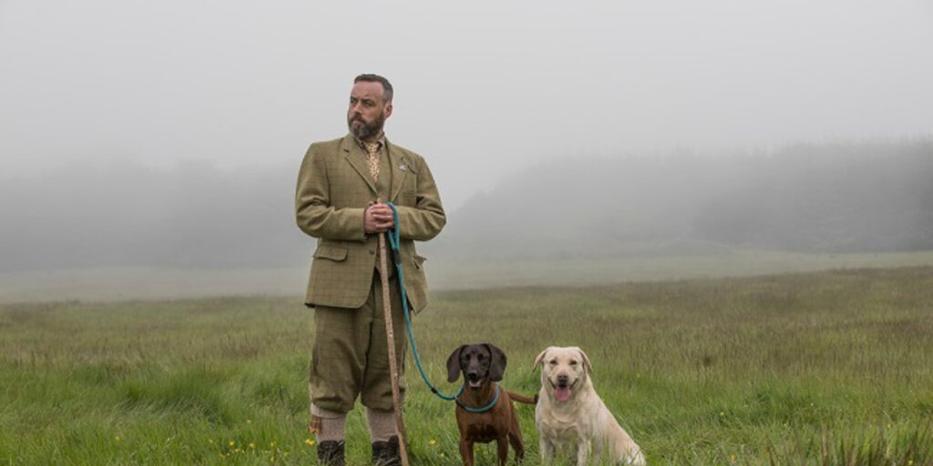 Game keeper in tweed with labrador and cocker