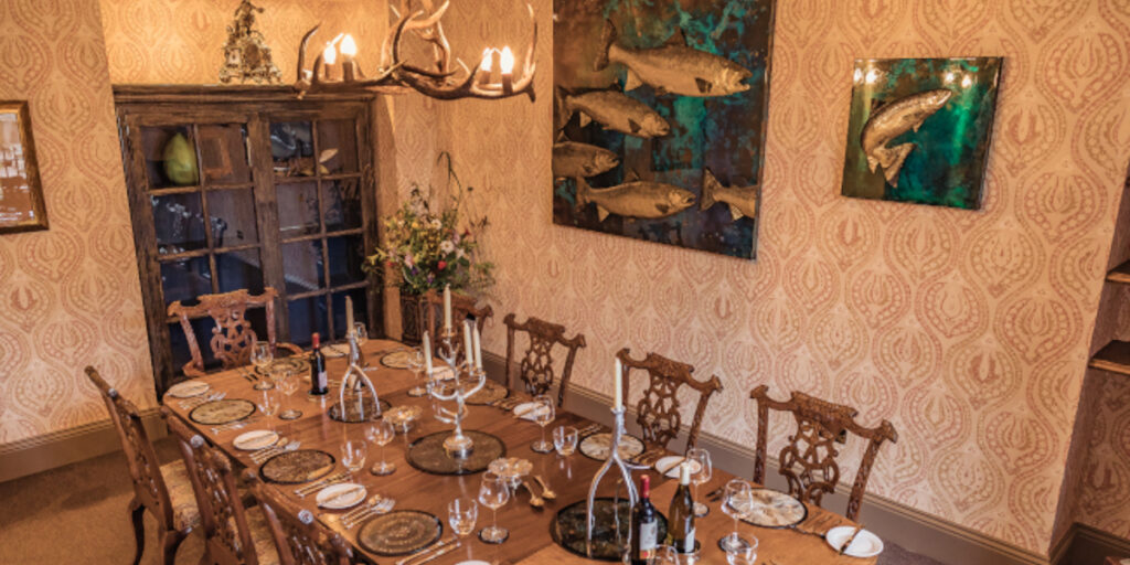 dining room table set for dinner with salmon artwork on wall