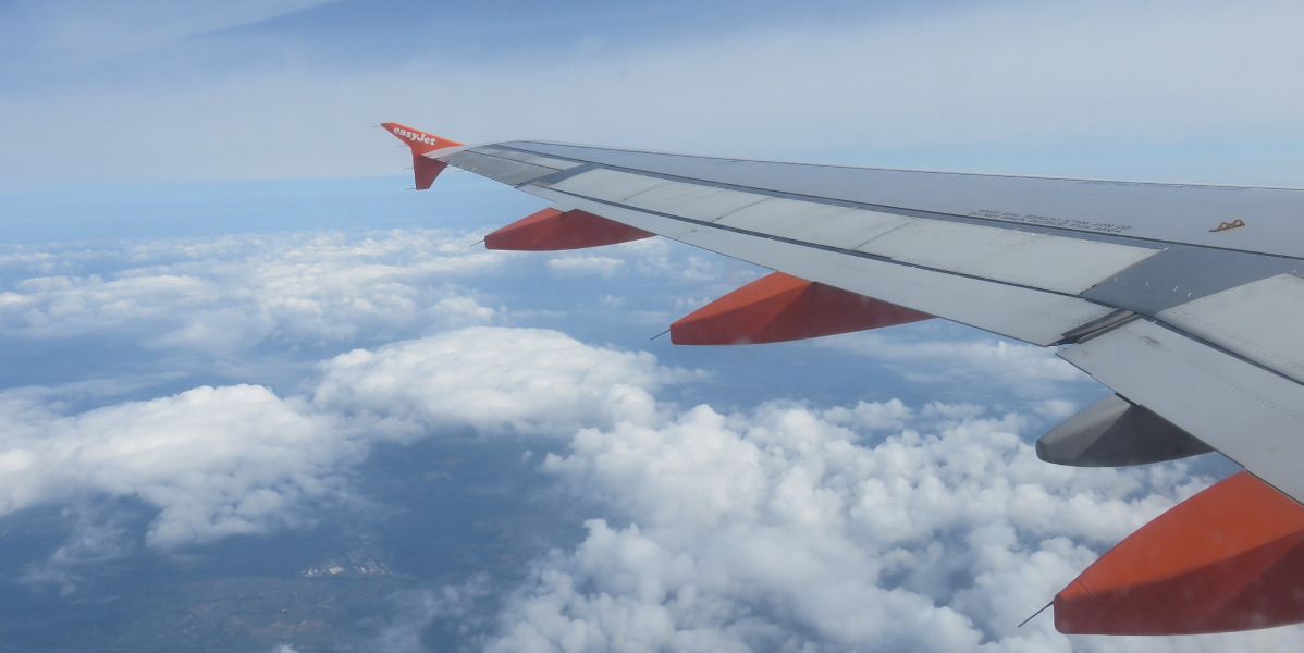 grey and orange aircraft wing in flight