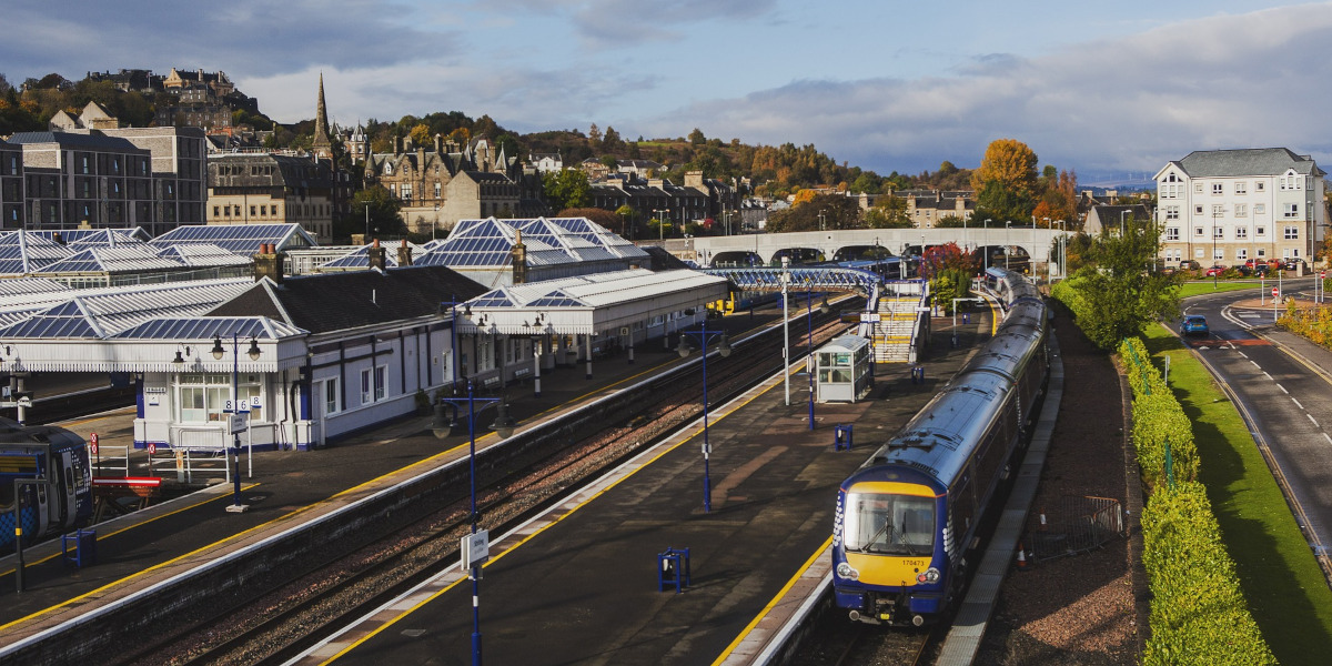 blue coloured train travelling through station in Edinburgh