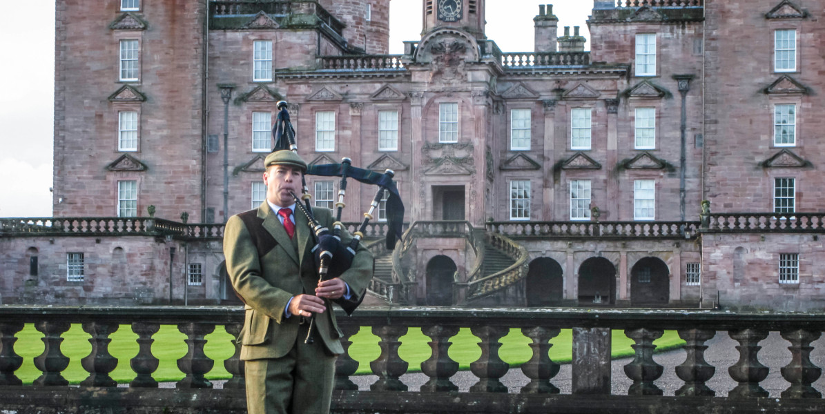 bagpiper outside a castle