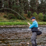 Angler playing an atlantic salmon river Dee Scotland with Twinpeakesflyfishing 2100x 150x150